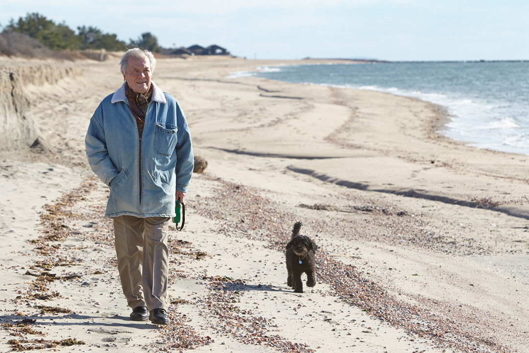 Photograph of Chef and Artist Jacques Pepin. Here’s Jacques on a beach walk with his dog, Paco.