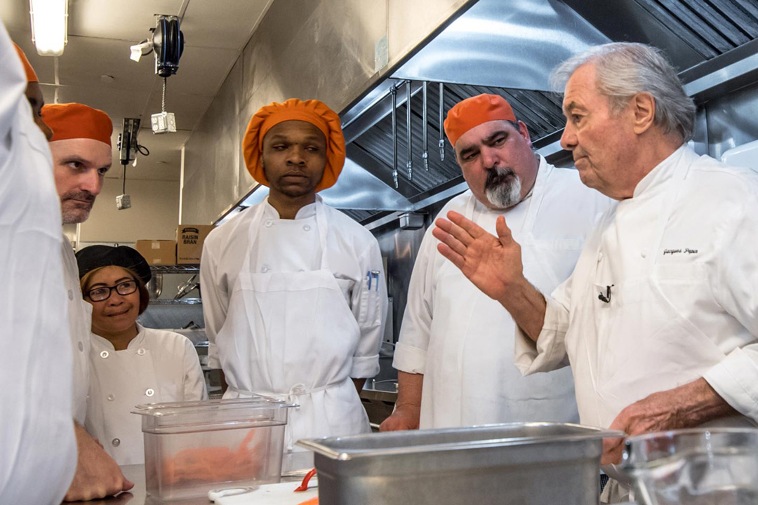 Photograph of Chef and Artist Jacques Pepin. Here’s Jacques with with several students. A portion of profits from the site go to help fund education and sustainability.
