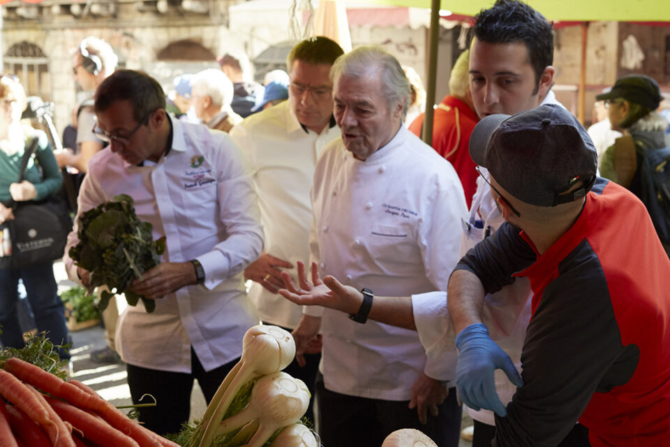 Oceania Cruises’ Executive Culinary Director Jacques Pepin choosing fresh produce in a port-of-call market. Oceania’s Culinary Director—France, Franck Garanger, is to Jacques’ right.